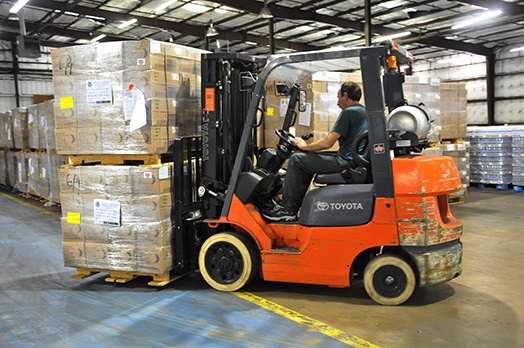 Tyler, TX September 2,2008-- A member of the Texas Forest Service moves a batch of MRE (meals ready to eat) in a warehouse in Tyler, TX.supplies in a  The warehouse is being used to handle basic supplies of water and MRE (meals ready to eat) for distribution to residents affected by Hurricane Gustav.  Photo by Patsy Lynch/FEMA